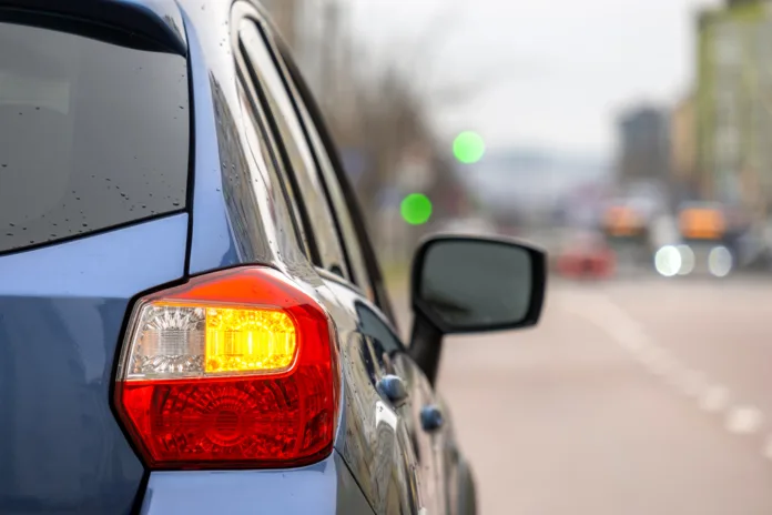 Carro azul com seta ligada em via urbana, representando apreensão de veículo em decisão judicial.