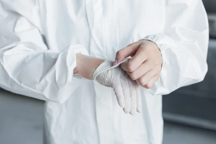 Profissional de saúde vestindo luvas descartáveis e equipamento de proteção. Imagem ilustrativa para matéria sobre desinformação médica e ações judiciais.