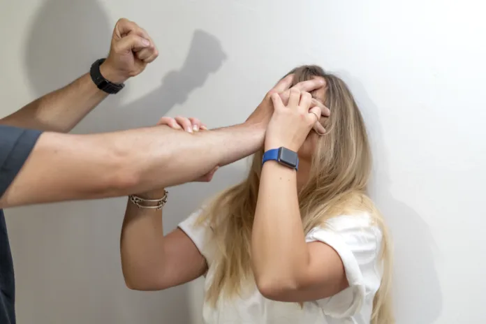 Mulher tentando se defender de agressão física de um homem, representando a violência contra mulheres. Imagem ilustrativa sobre lesão corporal grave e medidas de combate à violência de gênero.